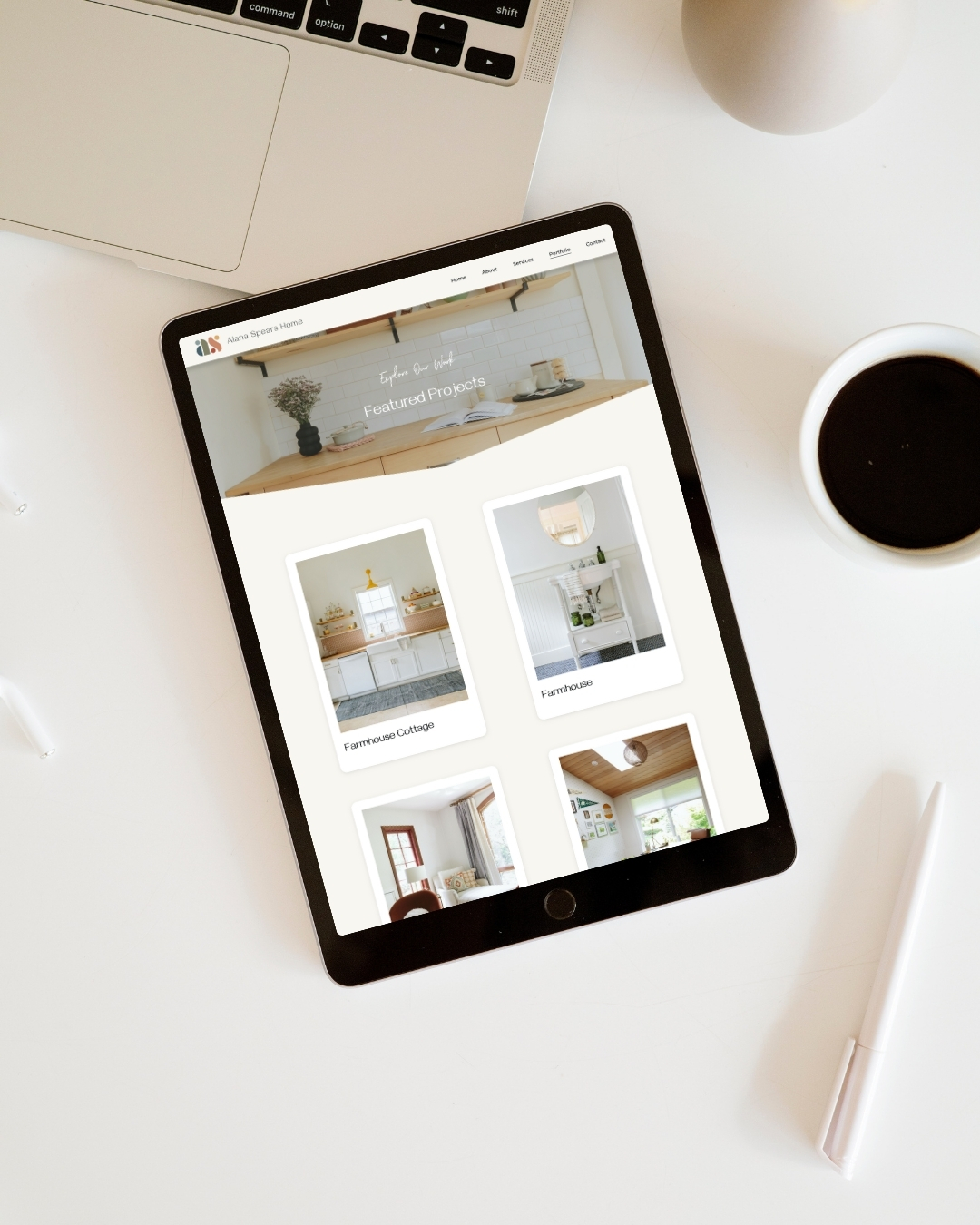 Pad on a white desk displaying the portfolio page of Alana Spears Home, an interior design website, showing featured projects including Farmhouse Cottage and other residential spaces